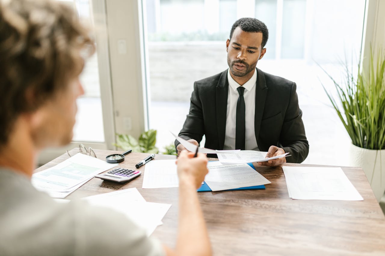Crafting Captivating Headlines: Your awesome post title goes here Businessman in a suit reviewing documents during a meeting indoors with a colleague.